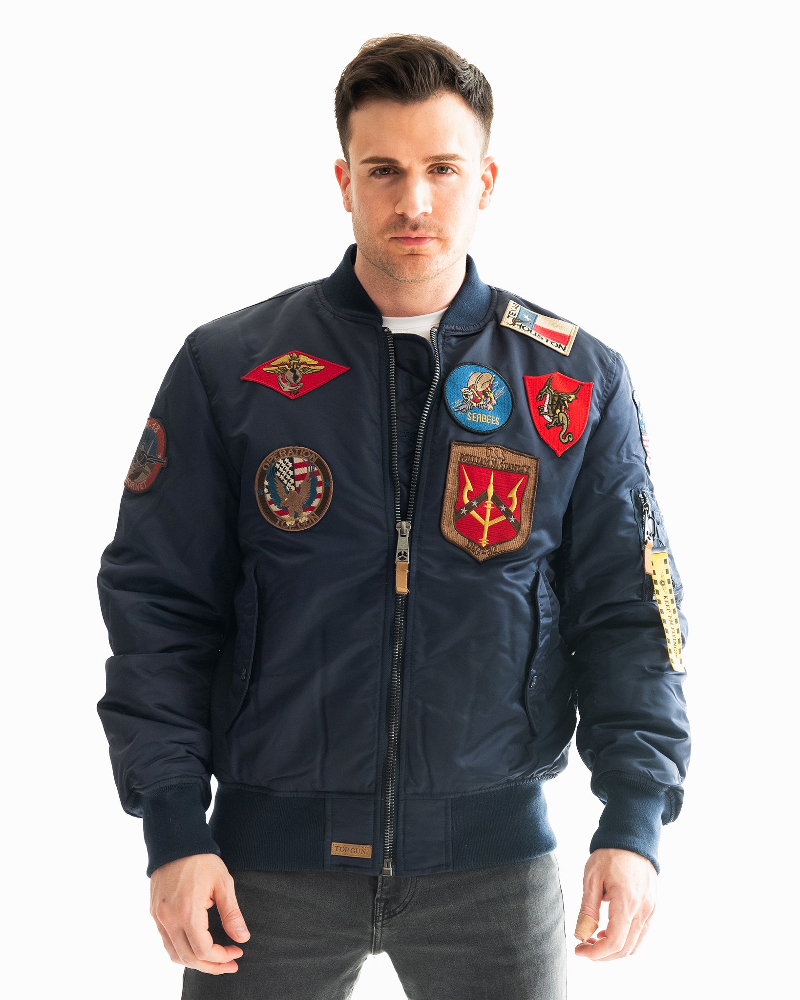 Man posing in the Top Gun® MA-1 bomber jacket with patches from another angle #color_navy
