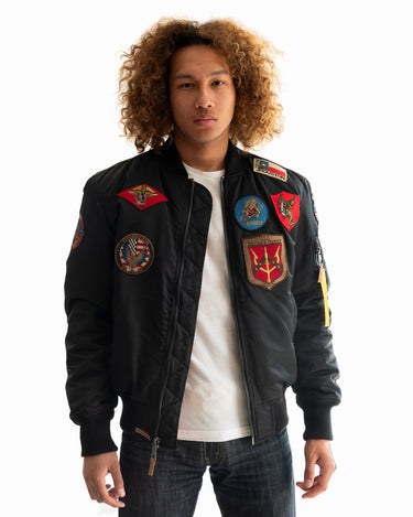 Side view of a man with curly hair wearing the black Top Gun® MA-1 bomber jacket #color_black