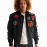 Side view of a man with curly hair wearing the black Top Gun® MA-1 bomber jacket #color_black