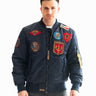 Man posing in the Top Gun® MA-1 bomber jacket with patches from another angle #color_navy