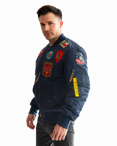 Man posing in the Top Gun® MA-1 bomber jacket adorned with patches #color_navy